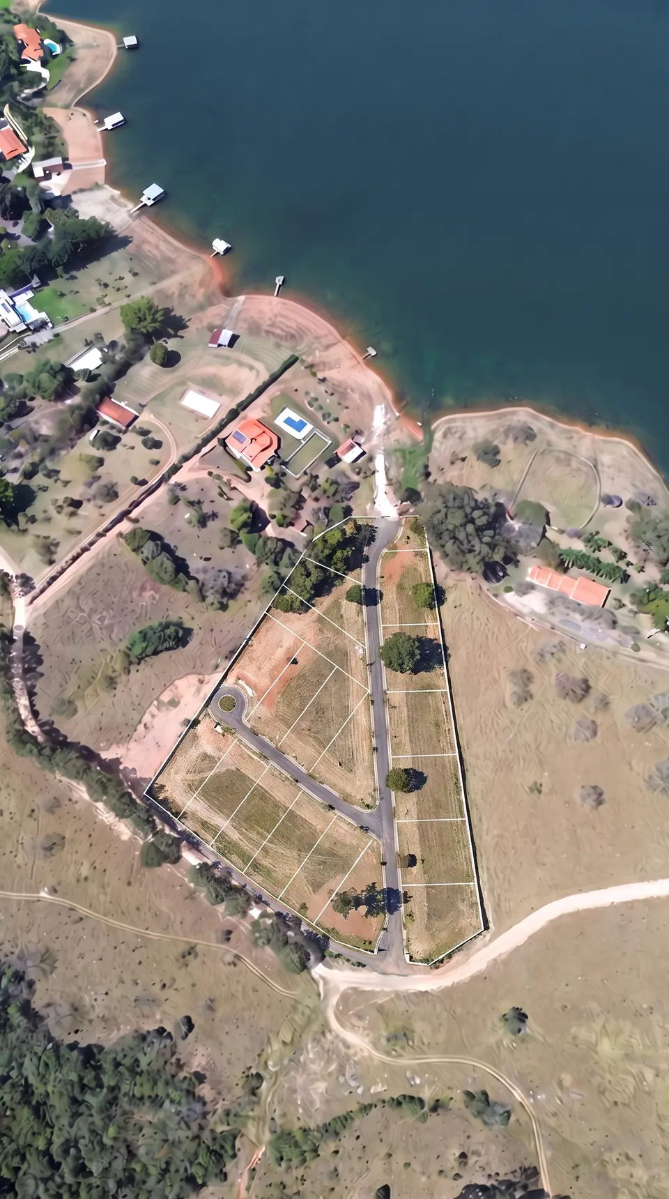 Vista aérea do terreno com os lotes demarcados ao lado da represa